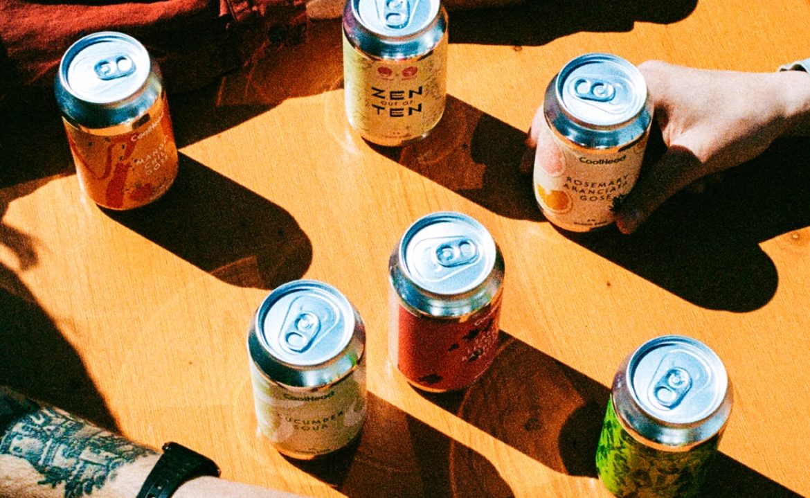 Photograph from the CoolHead website, showing a bunch of their beer cans on a table.