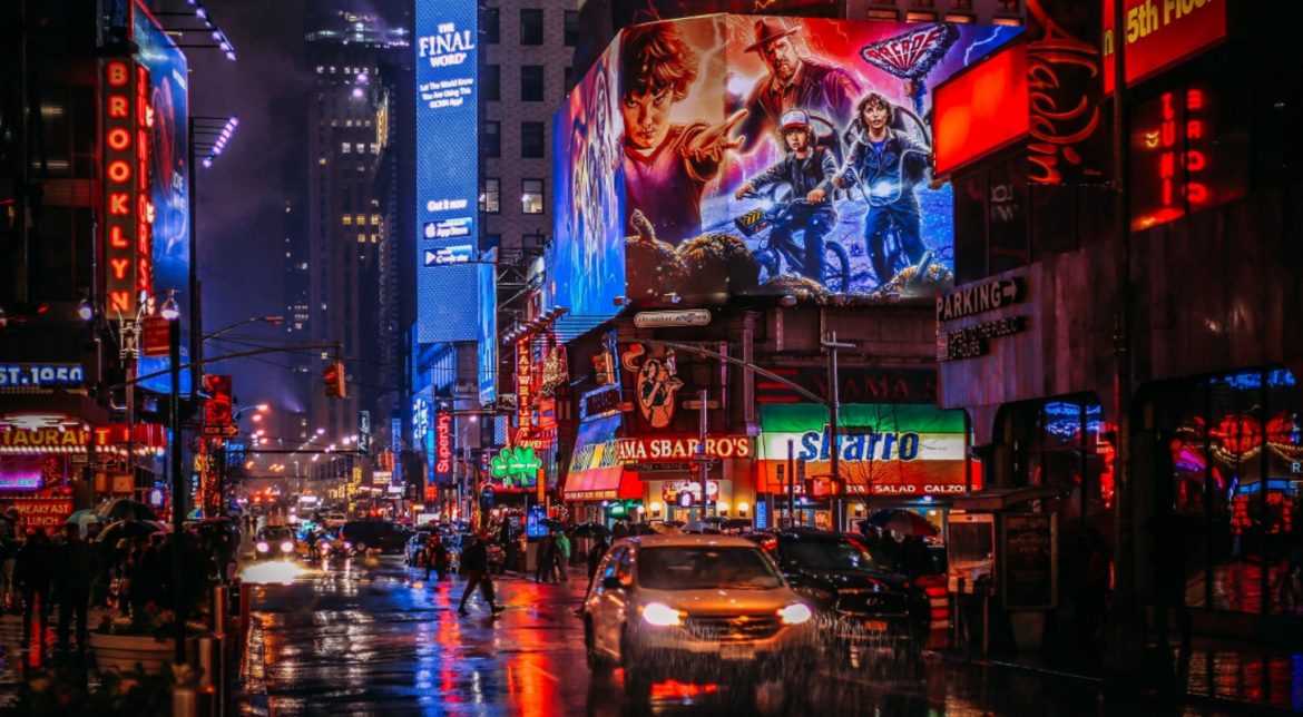 A photograph of a city at night, with dozens of neon signs lighting the scene.