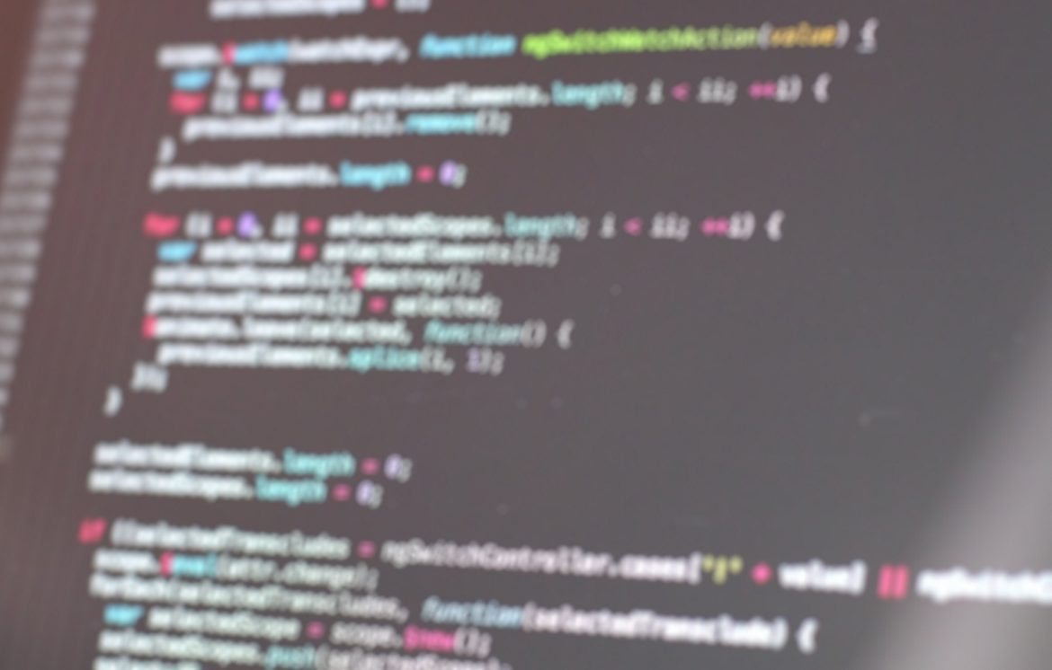 A blurred photograph of a screen displaying code.