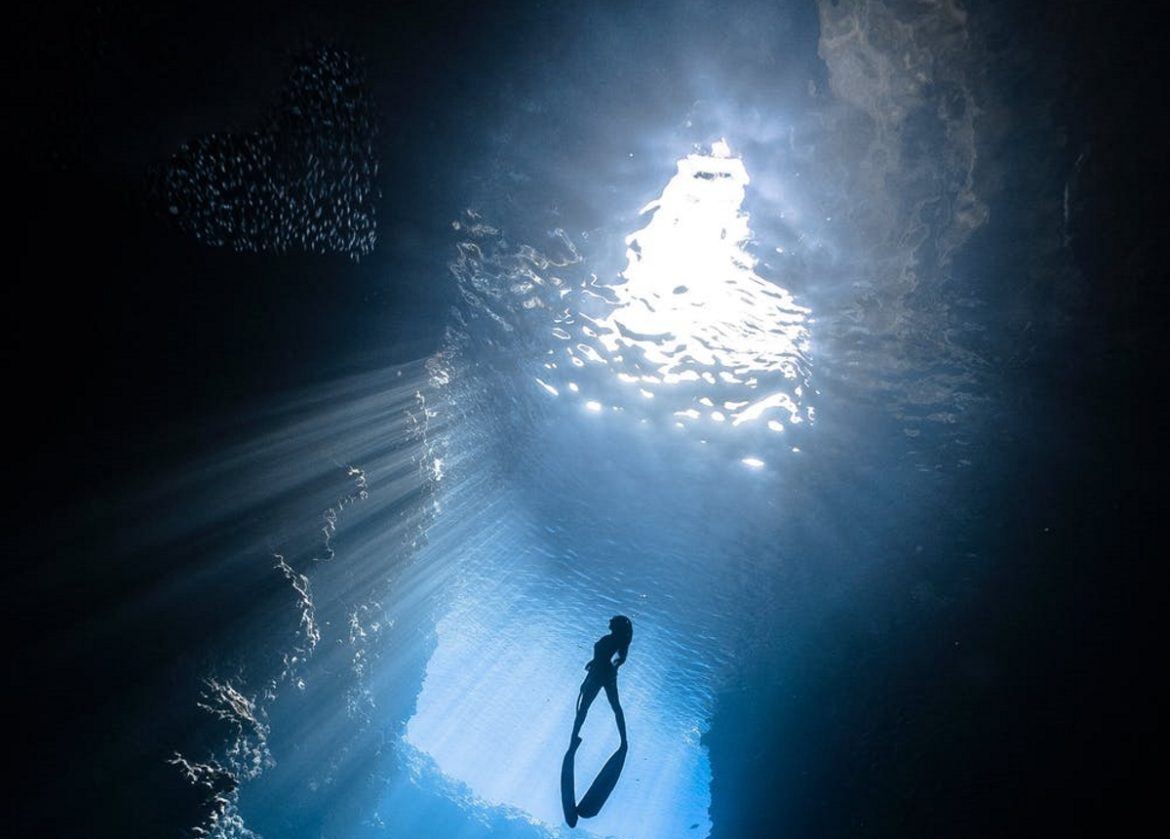 A photograph of a scuba diver in an ice cave.