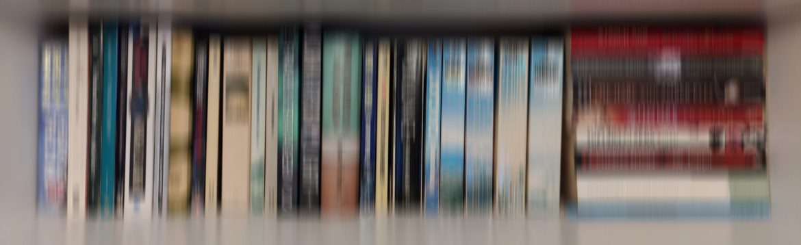 A blurred photograph of books on a shelf.
