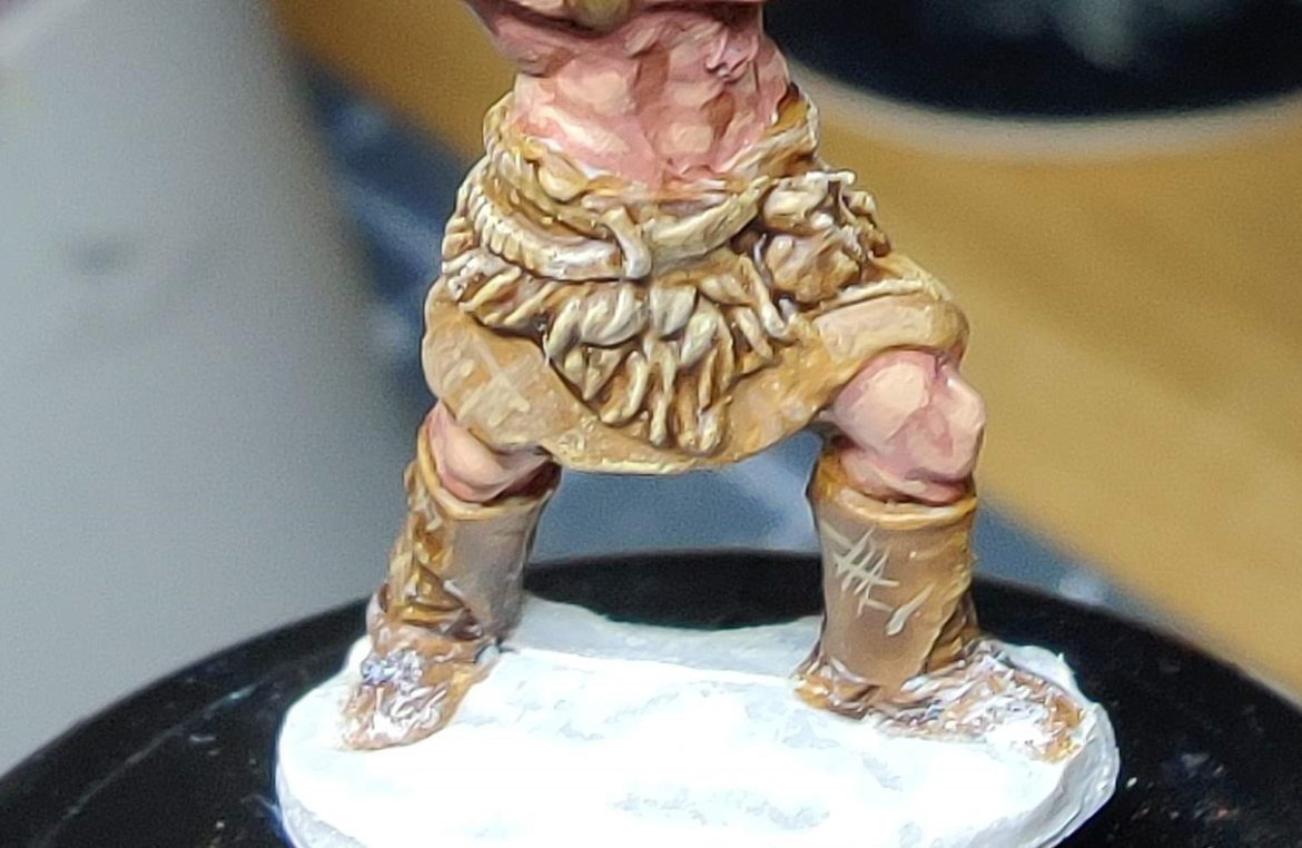 A close-up of the barbarian's waist and feet, displaying the leather texture and snow effects.