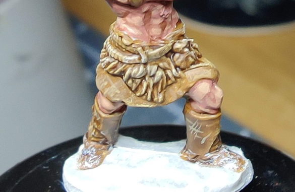 A close-up of the barbarian's waist and feet, displaying the leather texture and snow effects.
