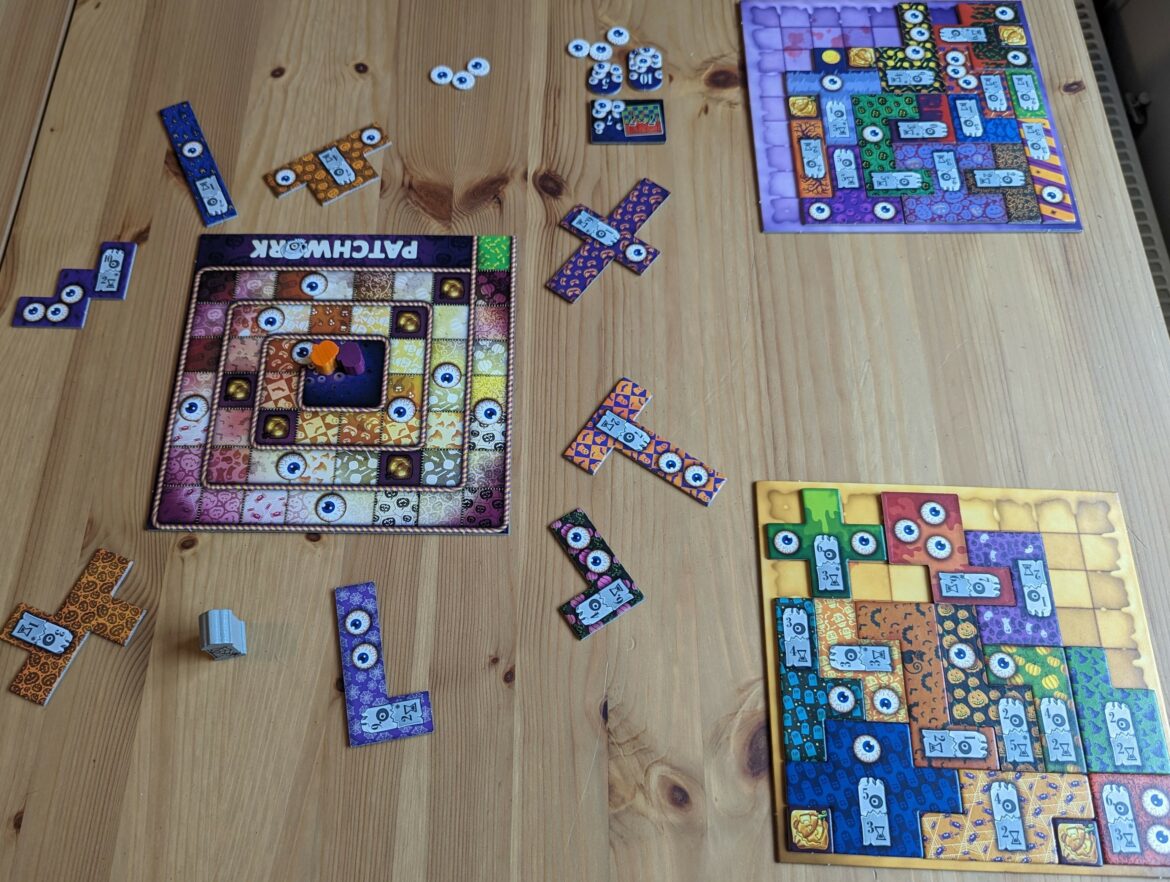 Photograph of all three Patchwork boards used in a two-player game. The game is heading towards a close!